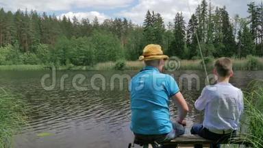 父子俩在河边的长凳上钓鱼